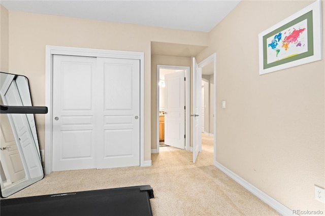 exercise area with baseboards and carpet flooring