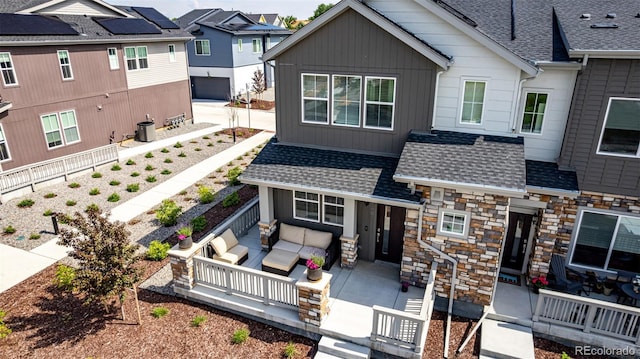 1500 Sun Way, Lafayette, CO 80026 - view of front facade featuring roof with shingles, outdoor lounge area, stone siding, a porch, and board and batten siding