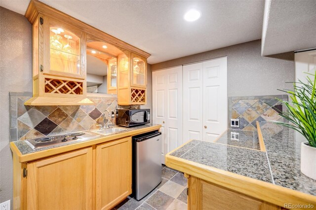 3889 S Fraser St, Aurora, CO 80014 - kitchen with refrigerator, stainless steel stovetop, tasteful backsplash, black microwave, and tile counters