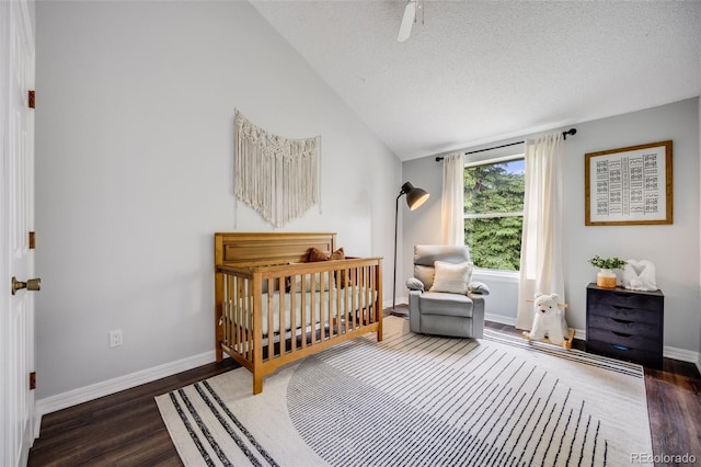 3889 S Fraser St, Aurora, CO 80014 - bedroom featuring a nursery area, vaulted ceiling, wood finished floors, and a textured ceiling
