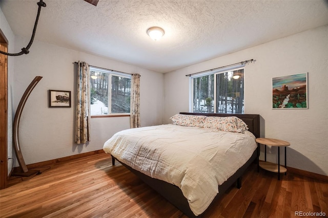 46 Apache Rd, Evergreen, CO 80439 - bedroom featuring baseboards, multiple windows, and wood finished floors