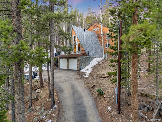 46 Apache Rd, Evergreen, CO 80439 - view of front of house with roof with shingles, driveway, stone siding, and an attached garage