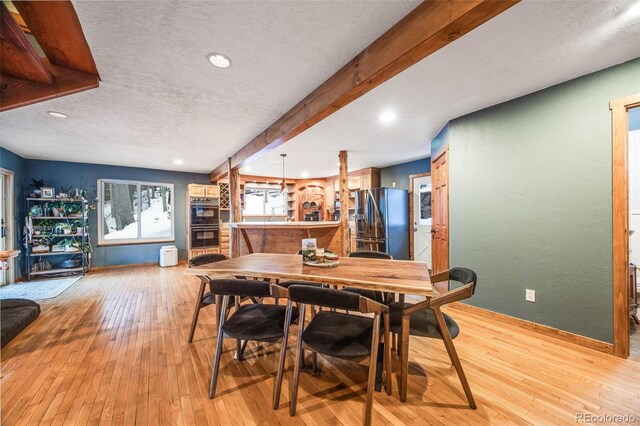 46 Apache Rd, Evergreen, CO 80439 - dining space with light wood-type flooring, beamed ceiling, a textured ceiling, and recessed lighting