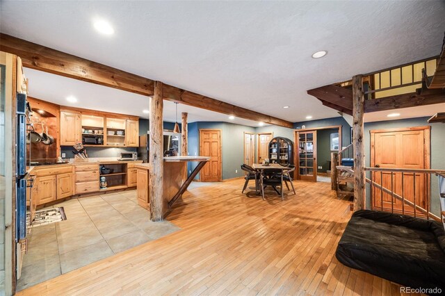 46 Apache Rd, Evergreen, CO 80439 - kitchen with light wood-style floors, a kitchen breakfast bar, light brown cabinetry, open shelves, and recessed lighting
