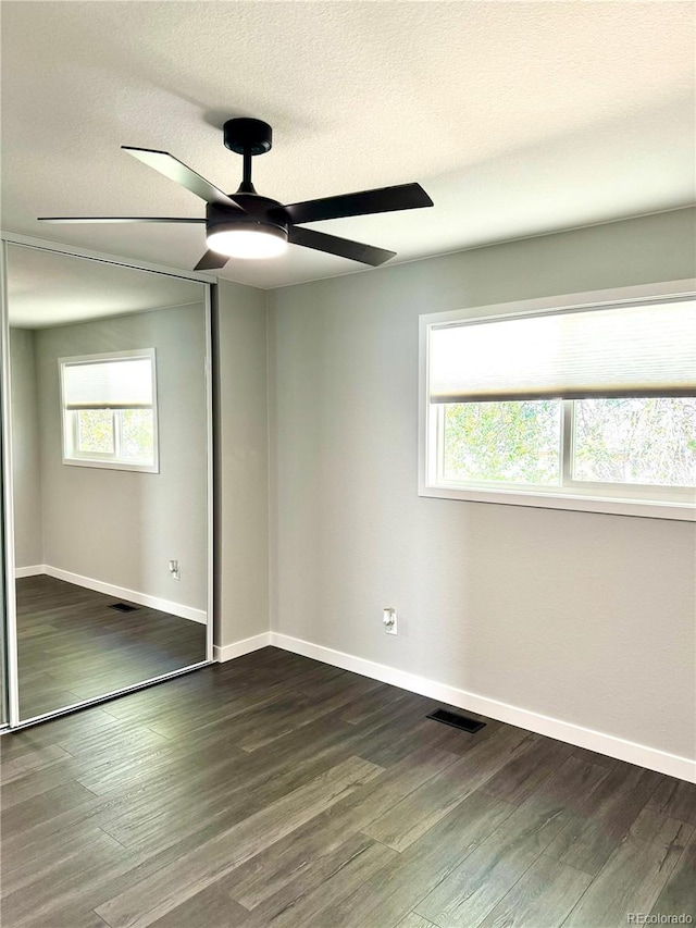 spare room featuring a textured ceiling, dark hardwood / wood-style flooring, and ceiling fan