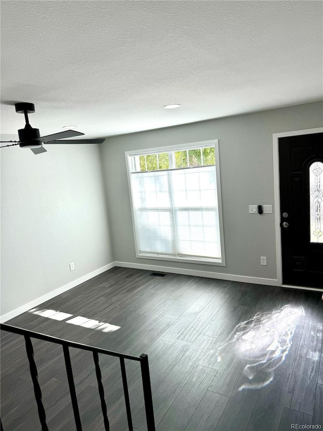 entrance foyer featuring a textured ceiling, dark hardwood / wood-style flooring, and ceiling fan