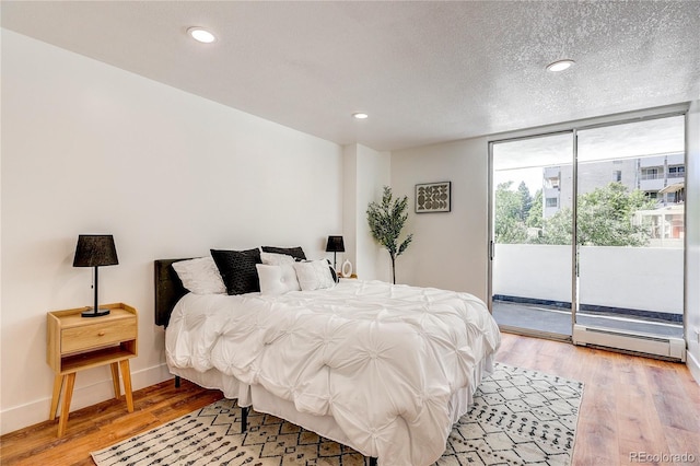 1250 N Humboldt St Unit 202, Denver, CO 80218 - bedroom featuring access to outside, light wood-style floors, a baseboard heating unit, a wall of windows, and recessed lighting