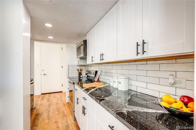 1250 N Humboldt St Unit 202, Denver, CO 80218 - kitchen featuring appliances with stainless steel finishes, white cabinetry, backsplash, a textured ceiling, and light wood-style flooring