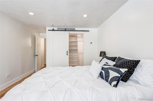 1250 N Humboldt St Unit 202, Denver, CO 80218 - bedroom with a textured ceiling, recessed lighting, wood finished floors, and a closet
