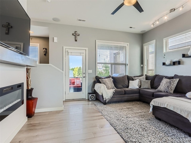 living room with ceiling fan and light hardwood / wood-style flooring