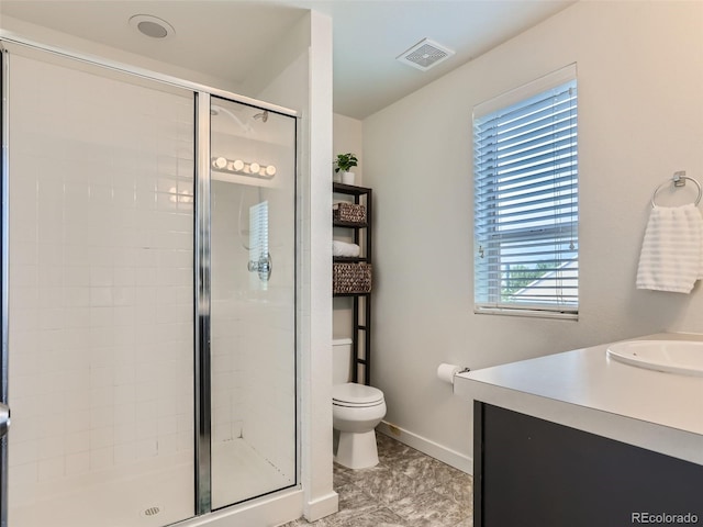 bathroom with toilet, vanity, and walk in shower