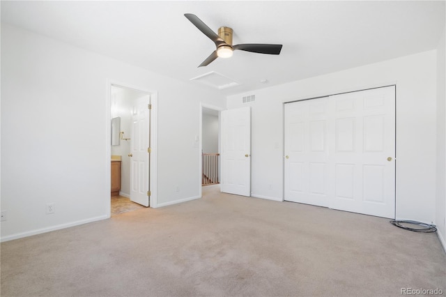 unfurnished bedroom featuring ensuite bathroom, ceiling fan, light colored carpet, and a closet