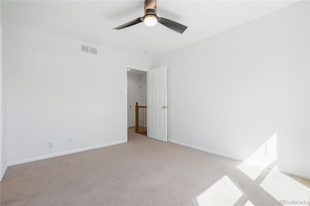 spare room featuring light carpet and ceiling fan