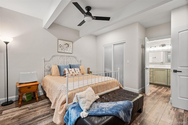 bedroom featuring connected bathroom, sink, ceiling fan, beam ceiling, and hardwood / wood-style floors