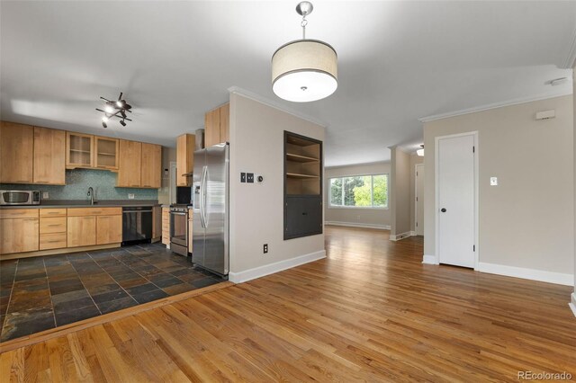 2672 S Magnolia St, Denver, CO 80224 - kitchen featuring stainless steel appliances, dark countertops, ornamental molding, dark wood-style flooring, and tasteful backsplash