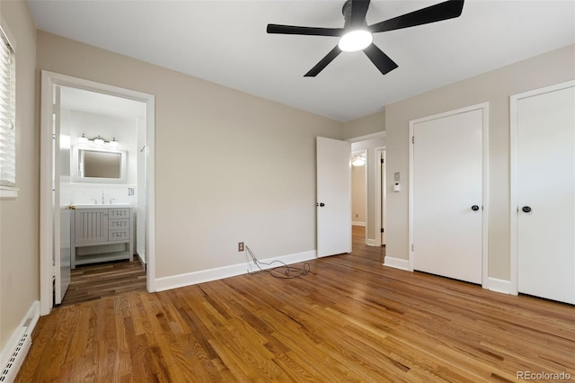 2672 S Magnolia St, Denver, CO 80224 - unfurnished bedroom with baseboard heating, light wood-style flooring, ensuite bath, multiple closets, and ceiling fan