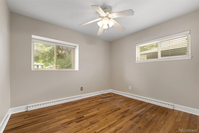 2672 S Magnolia St, Denver, CO 80224 - empty room featuring a baseboard radiator, plenty of natural light, and wood finished floors
