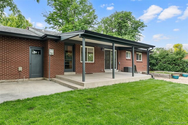 2672 S Magnolia St, Denver, CO 80224 - rear view of property featuring a lawn, a patio area, and brick siding