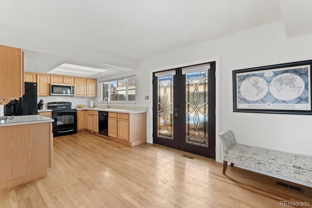 kitchen with light countertops, french doors, light brown cabinets, and black appliances