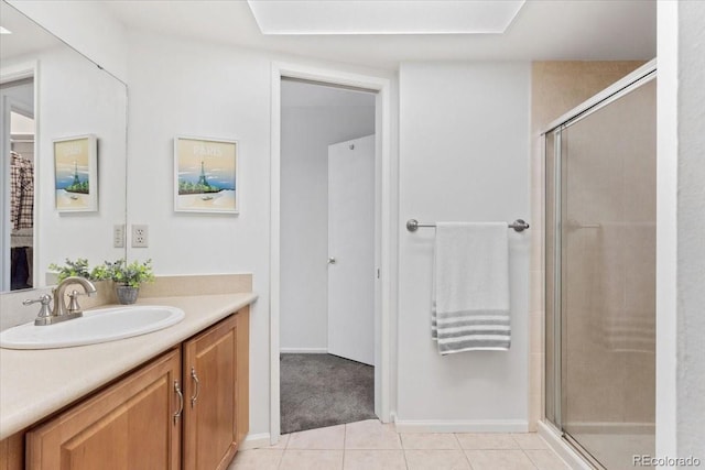 bathroom featuring a shower with door, tile patterned flooring, vanity, and baseboards