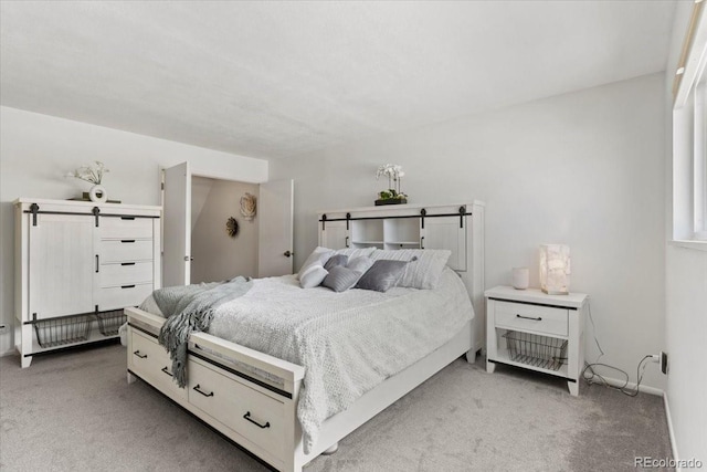 bedroom with baseboards and light colored carpet
