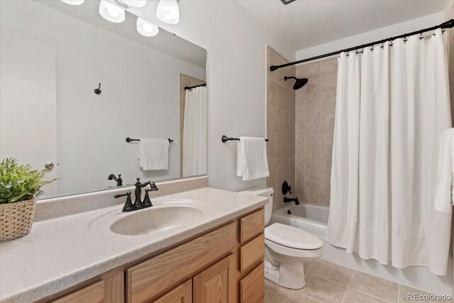 full bathroom featuring toilet, tile patterned floors, vanity, and shower / bath combo