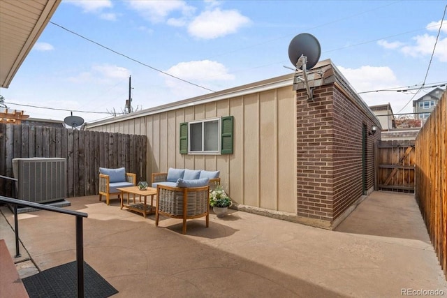 view of outdoor structure featuring outdoor lounge area, cooling unit, fence, and a gate