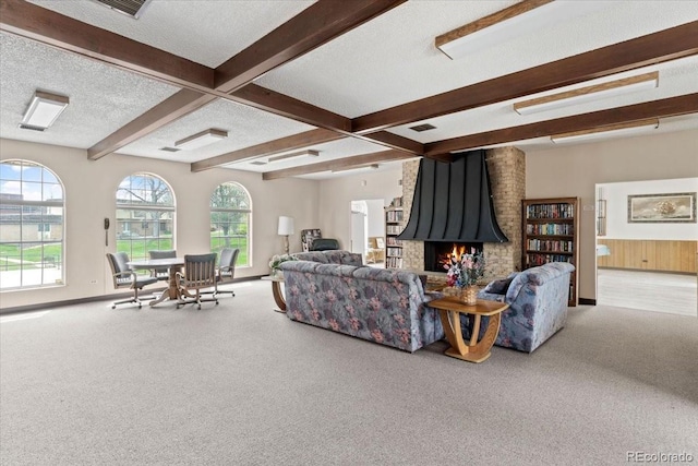 carpeted living room with visible vents, baseboards, a fireplace, a textured ceiling, and beam ceiling