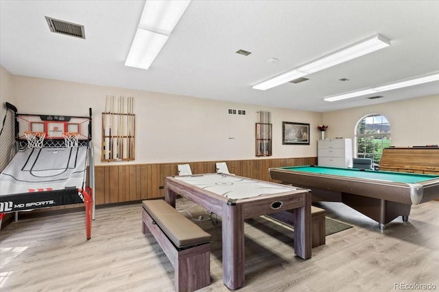 rec room featuring light wood-type flooring, wainscoting, and visible vents