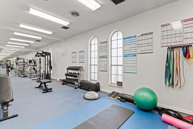 exercise room with visible vents and baseboards