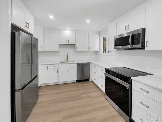 kitchen featuring white cabinets, light wood-type flooring, sink, and stainless steel appliances