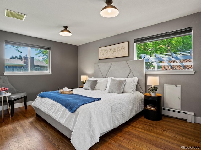 6943 Oak Way, Arvada, CO 80004 - bedroom featuring baseboard heating and wood finished floors