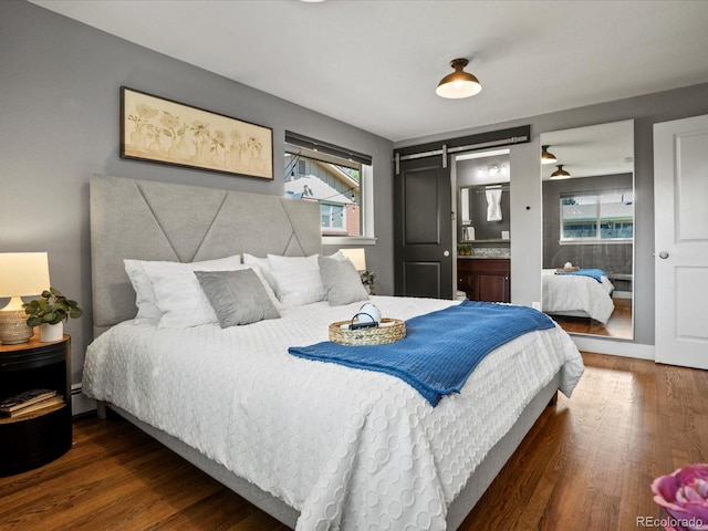 6943 Oak Way, Arvada, CO 80004 - bedroom with multiple windows, wood finished floors, a baseboard radiator, and a barn door