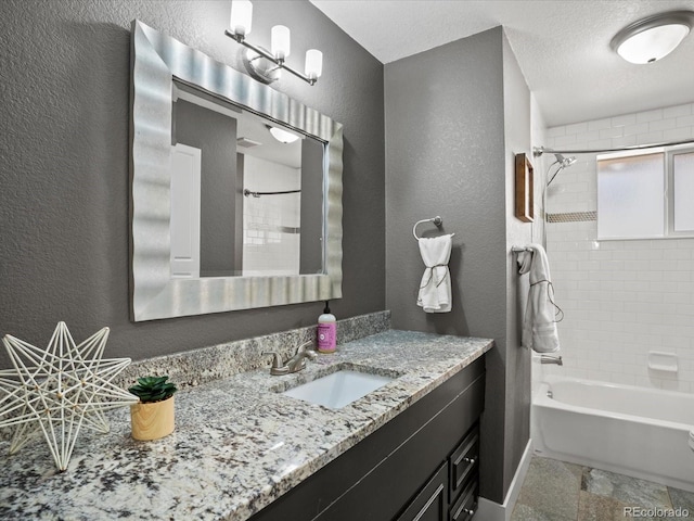 6943 Oak Way, Arvada, CO 80004 - bathroom featuring vanity, a textured wall, and tub / shower combination