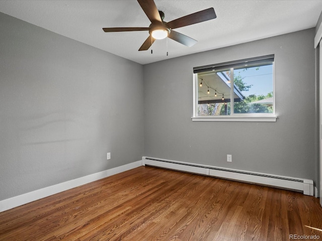 6943 Oak Way, Arvada, CO 80004 - spare room featuring a baseboard heating unit, wood finished floors, and ceiling fan