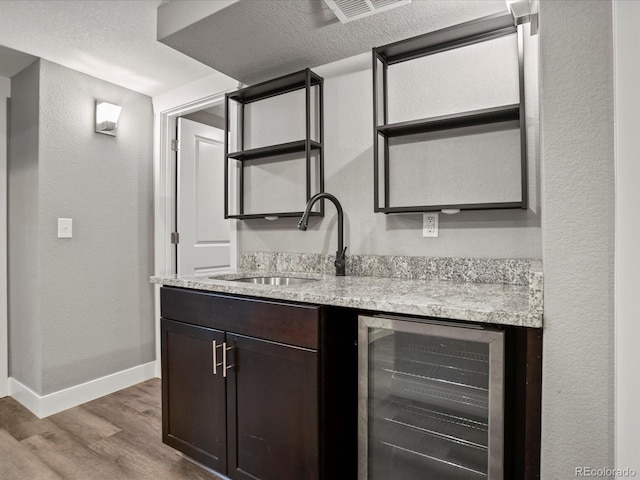 6943 Oak Way, Arvada, CO 80004 - indoor wet bar featuring beverage cooler, wood finished floors, and a textured wall