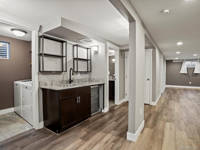 6943 Oak Way, Arvada, CO 80004 - indoor wet bar featuring separate washer and dryer, beverage cooler, and light wood-style flooring