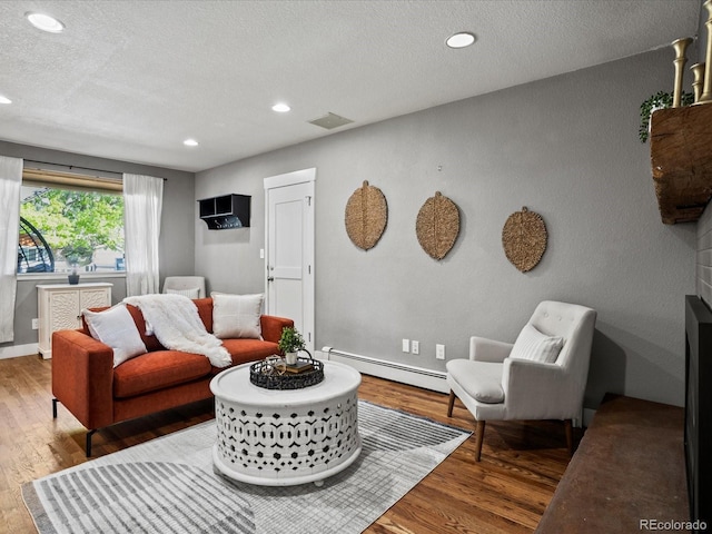 6943 Oak Way, Arvada, CO 80004 - living room with a baseboard radiator, wood finished floors, recessed lighting, and a textured ceiling