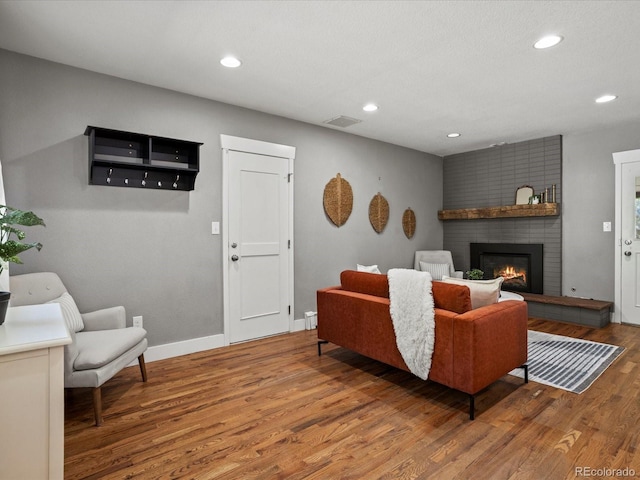 6943 Oak Way, Arvada, CO 80004 - living room with wood finished floors, a brick fireplace, and recessed lighting