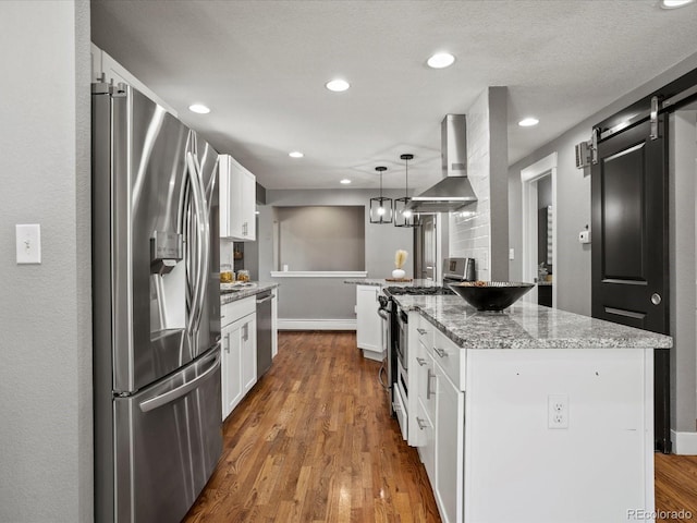 6943 Oak Way, Arvada, CO 80004 - kitchen with stainless steel appliances, wall chimney exhaust hood, white cabinetry, dark wood-type flooring, and recessed lighting