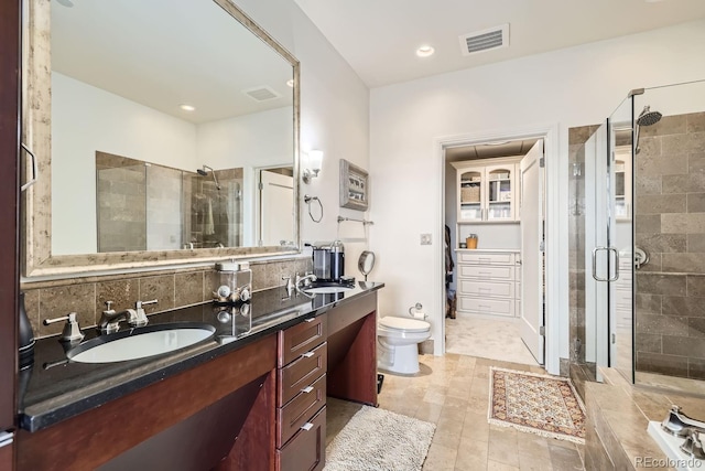 bathroom with vanity, decorative backsplash, toilet, and walk in shower