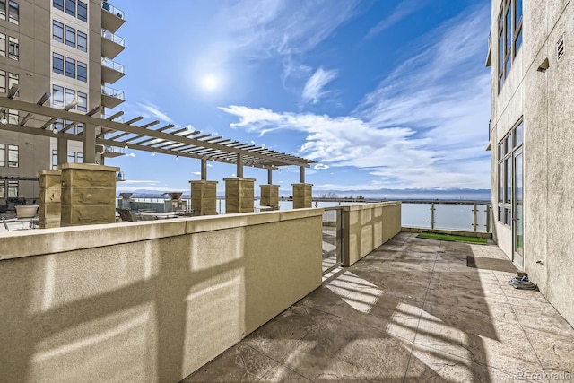 view of patio featuring a water view and a pergola