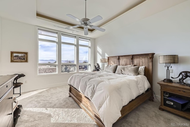 bedroom with a tray ceiling, carpet flooring, and ceiling fan