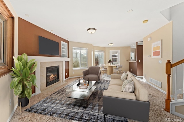 carpeted living room featuring a tile fireplace