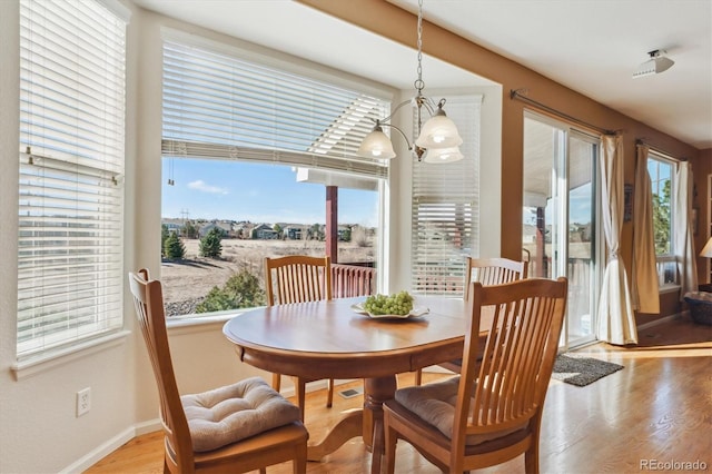 1022 Orion Way, Castle Rock, CO 80108 - dining area with healthy amount of natural light, wood finished floors, baseboards, and a chandelier