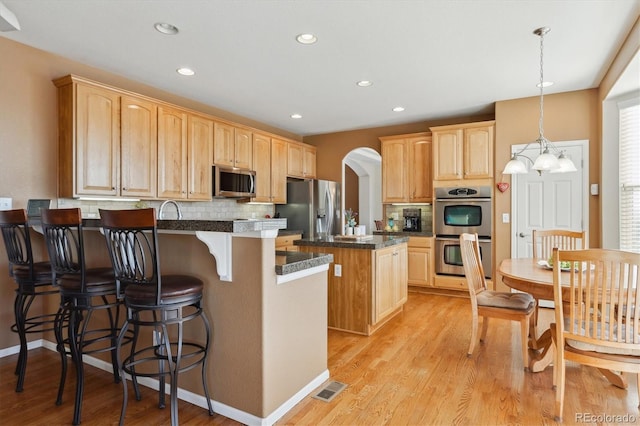 1022 Orion Way, Castle Rock, CO 80108 - kitchen featuring appliances with stainless steel finishes, a peninsula, light brown cabinetry, and recessed lighting