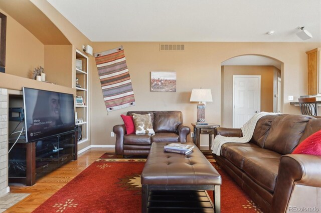1022 Orion Way, Castle Rock, CO 80108 - living area featuring light wood finished floors, arched walkways, baseboards, and built in features