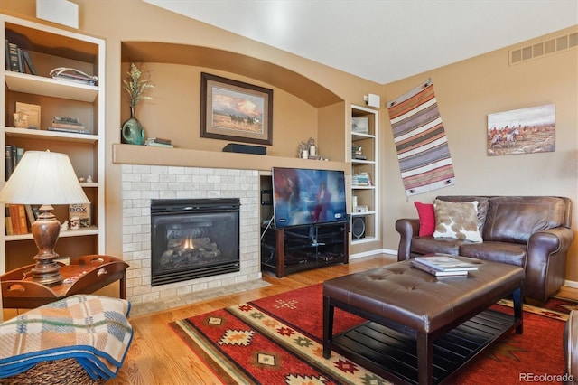 1022 Orion Way, Castle Rock, CO 80108 - living room with built in shelves, wood finished floors, a fireplace, and baseboards