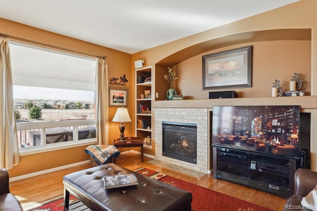 1022 Orion Way, Castle Rock, CO 80108 - living room featuring wood finished floors, a fireplace, built in features, and baseboards