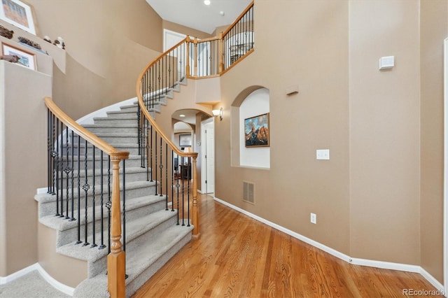 1022 Orion Way, Castle Rock, CO 80108 - stairway with arched walkways, wood finished floors, and a towering ceiling